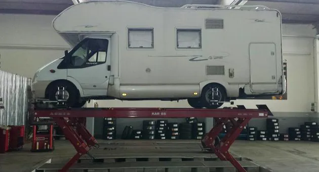 Meccanico che lavora su un cambio ruote per camper 